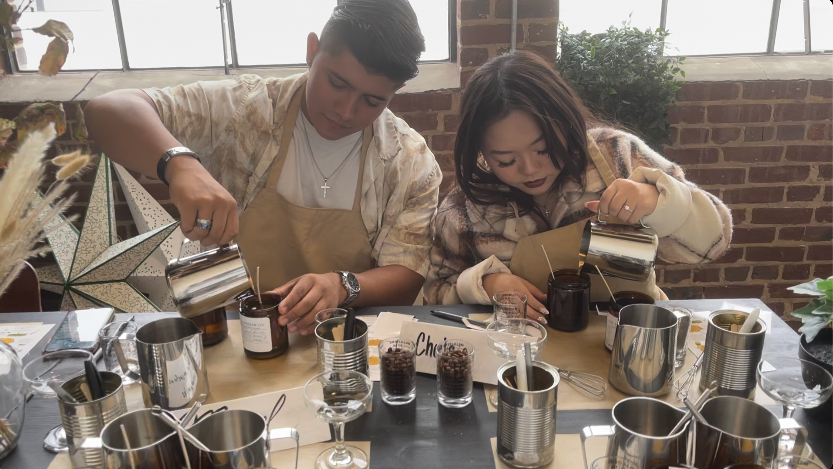 Guests hand-pouring luxury soy candles during a candle making class at Lot 23 Chandler Co. in Atlanta, Georgia, using premium fragrance oils in an intimate fragrance atelier.