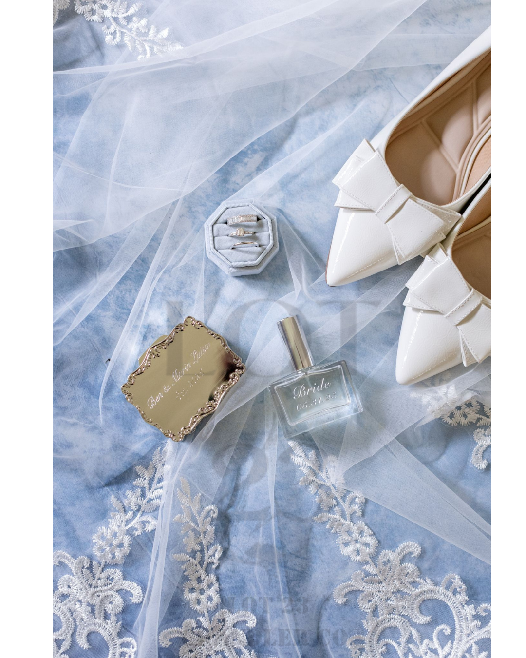 Lot 23 Chandler Co Custom Perfume for Wedding for the Bride White high-heeled shoes, compact mirror, and perfume bottle on a blue lace fabric