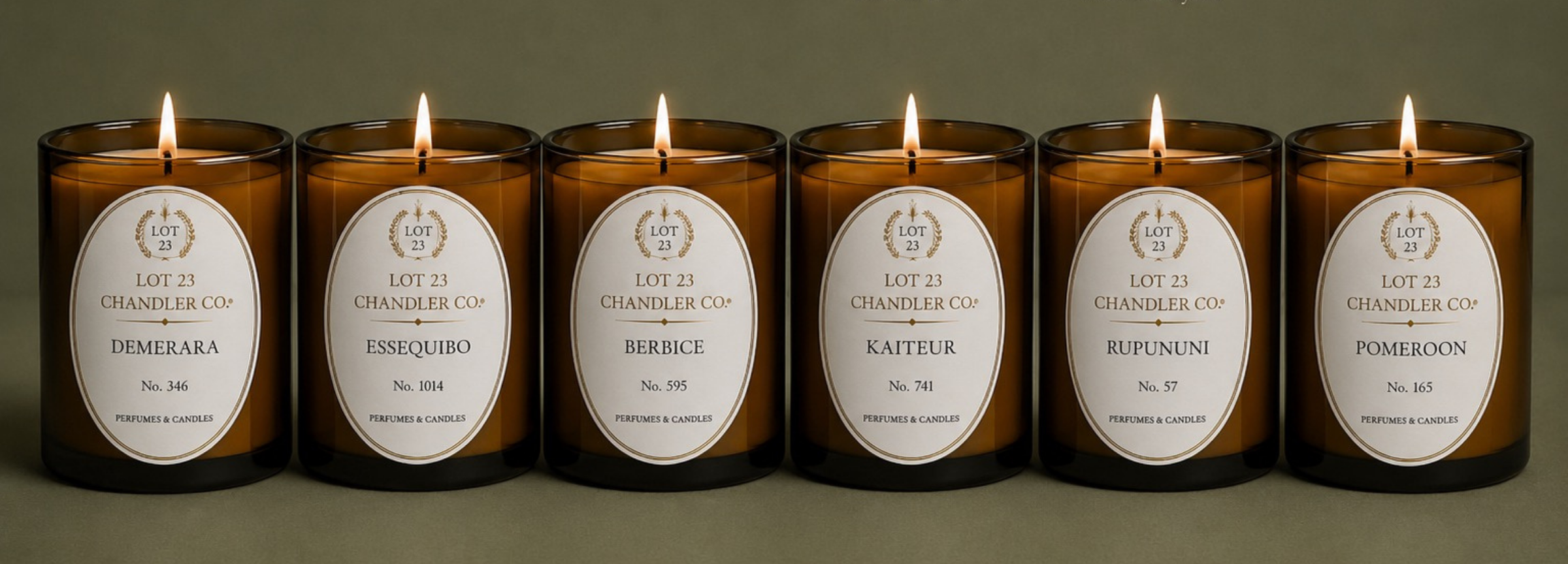 Collection of six luxury amber glass candles by Lot 23 Chandler Co., inspired by Guyana's regions including Demerara, Essequibo, Berbice, Kaieteur, Rupununi, and Pomeroon.